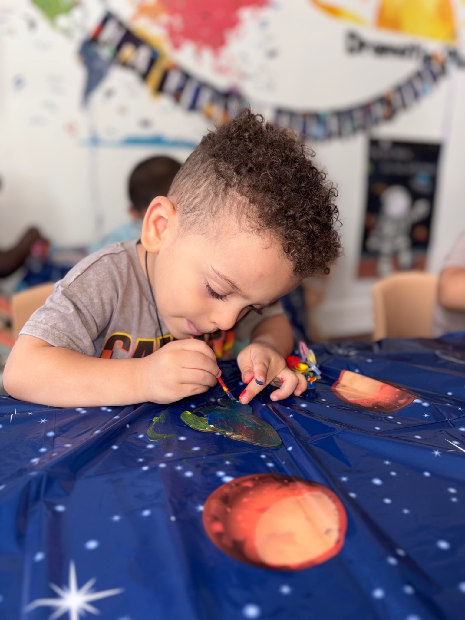 A child concentrating on a colorful painting activity